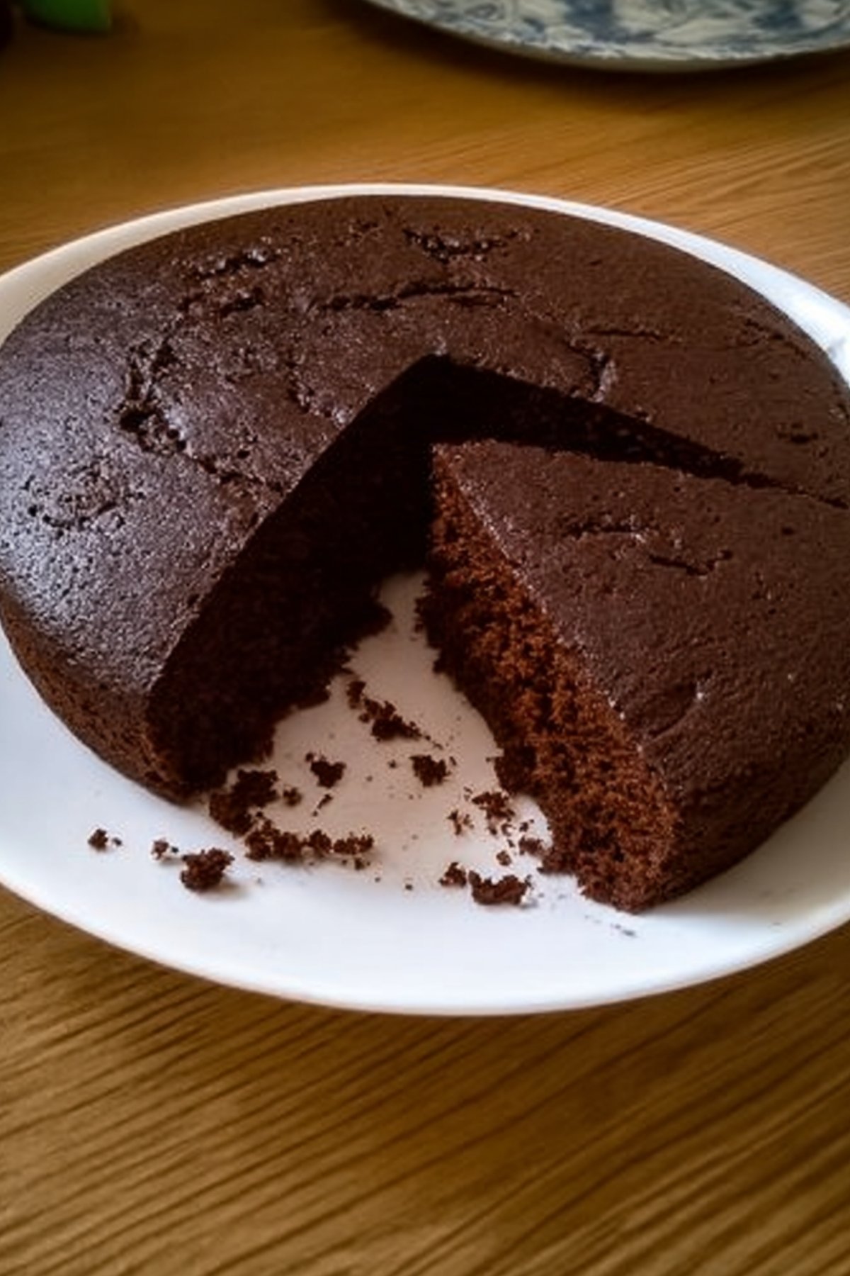 Gâteau au yaourt au cacao moelleux présenté sur une assiette avec une tranche découpée.