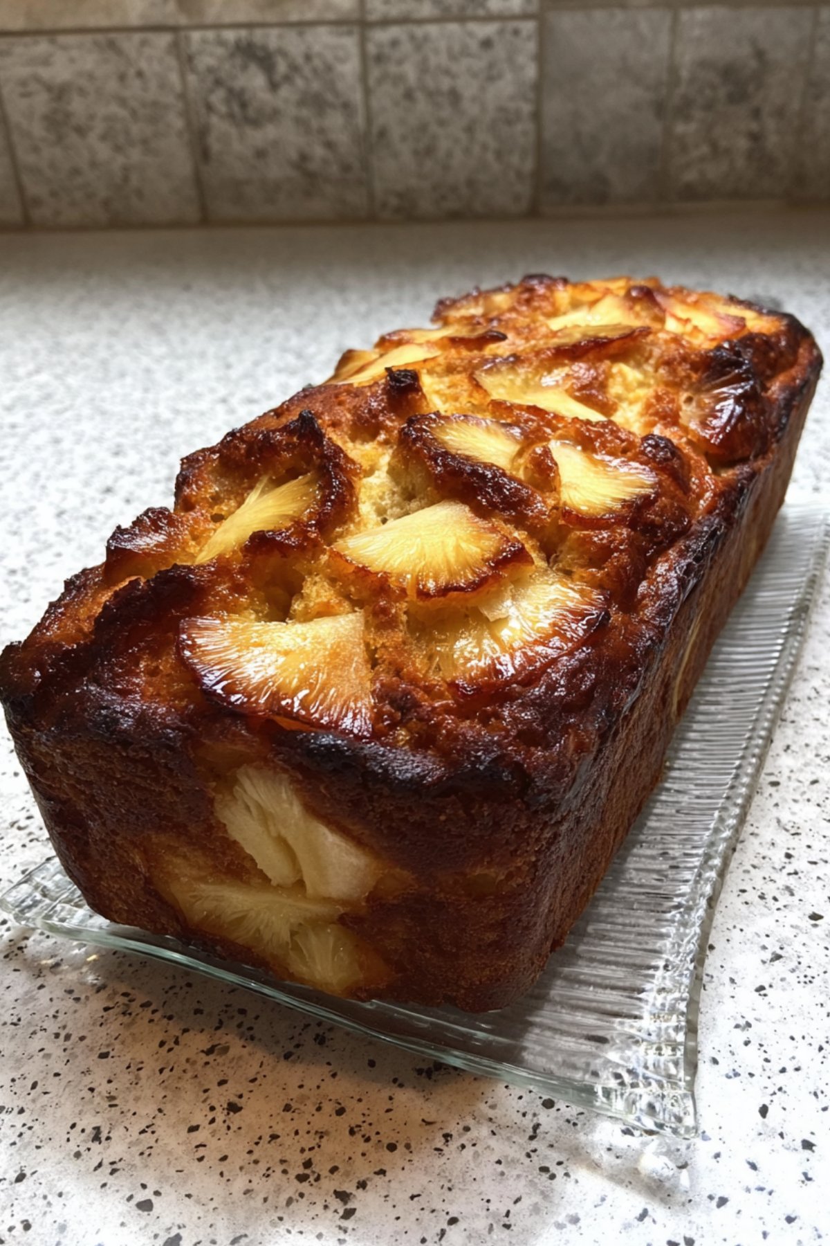 Gros plan sur un gâteau yaourt ananas et pommes maison, doré au four avec morceaux de fruits visibles, dessert moelleux et gourmand.