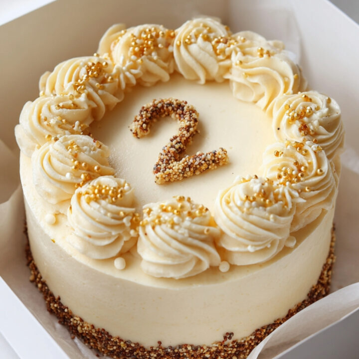 Bento cake vanille décoré avec crème au beurre et perles dorées, chiffre 2 en sucre sur le dessus.