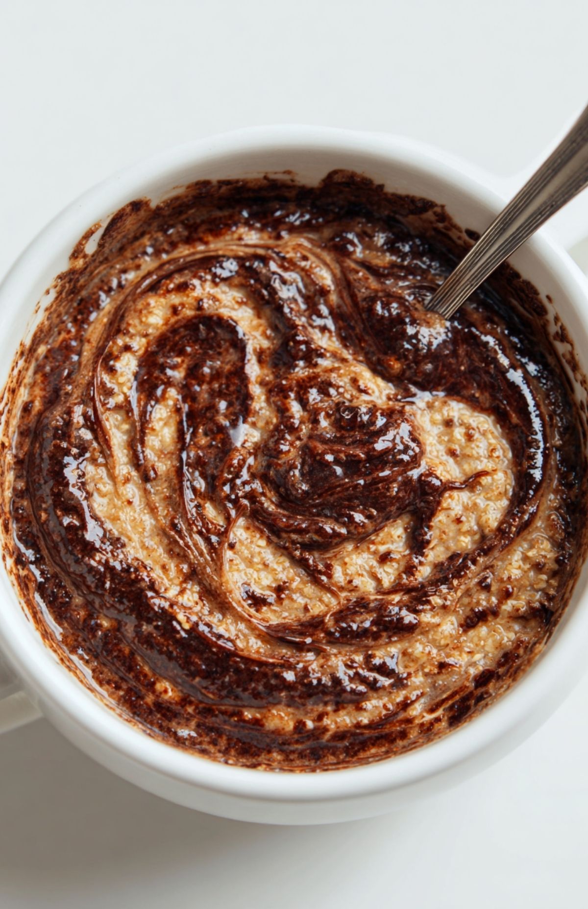 Mélange chocolaté onctueux dans bol blanc pour bowl cake au Nutella prêt à cuire