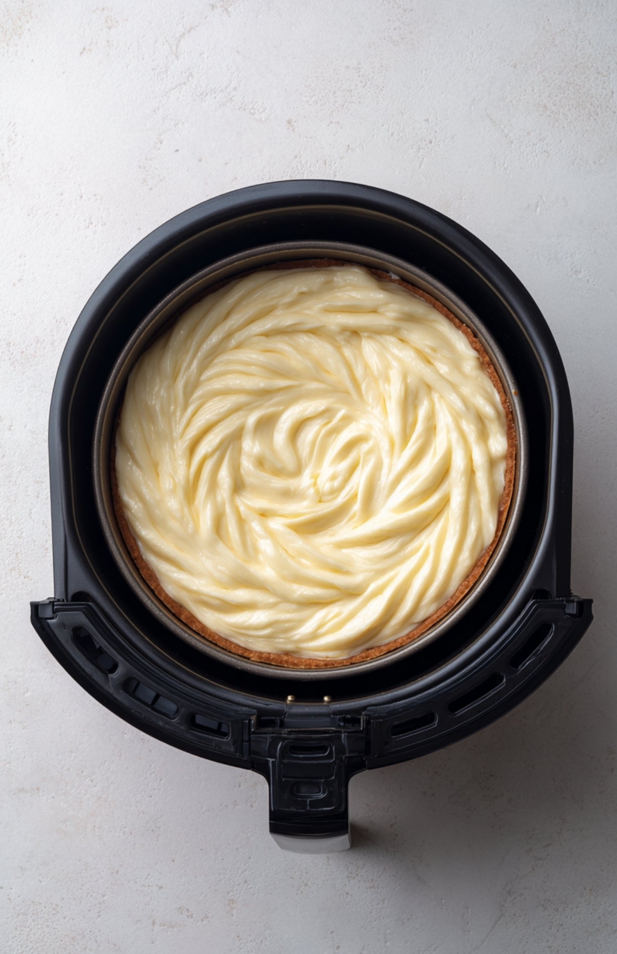 Moule rempli de pâte à gâteau compote de pomme placé dans l'air fryer