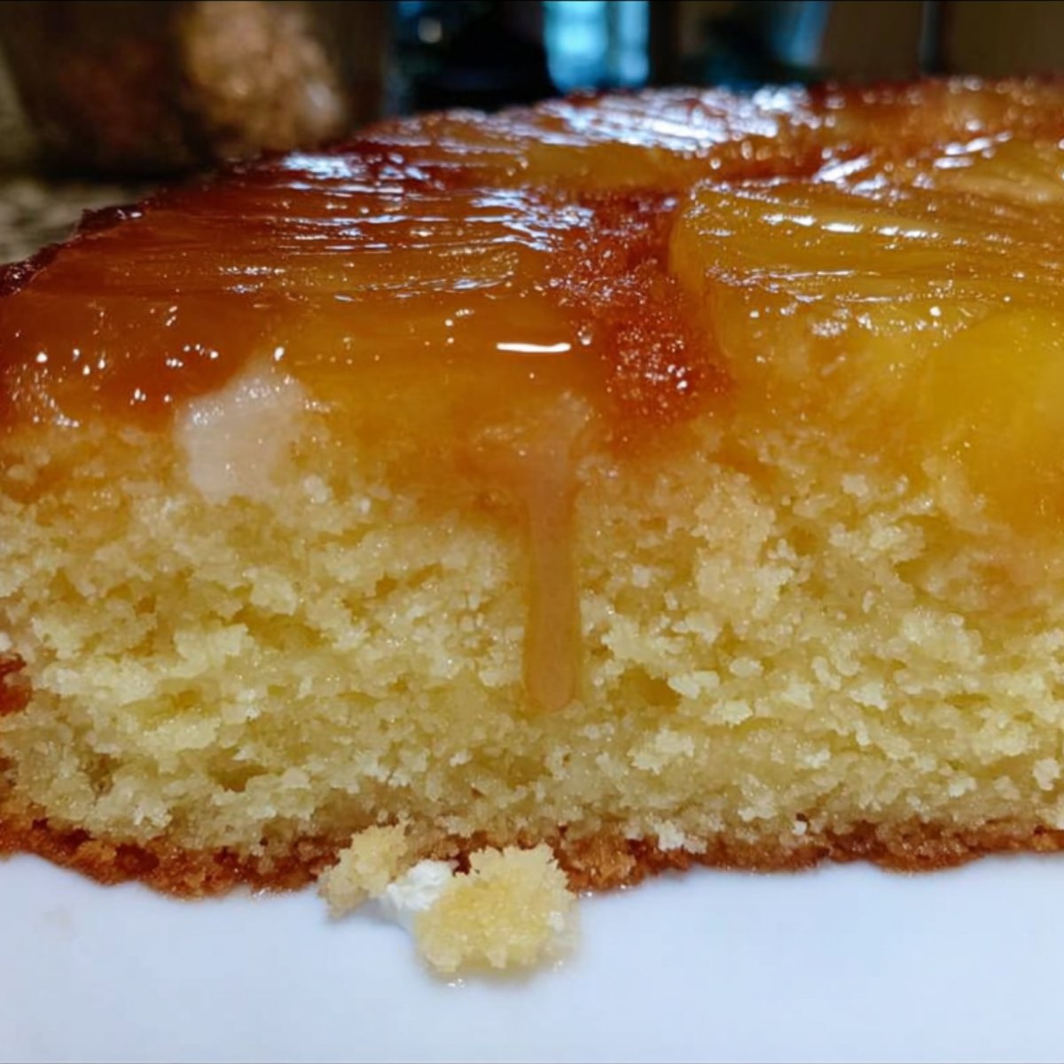 Intérieur moelleux du gâteau au yaourt et ananas caramélisé, texture fondante et visuellement dorée.