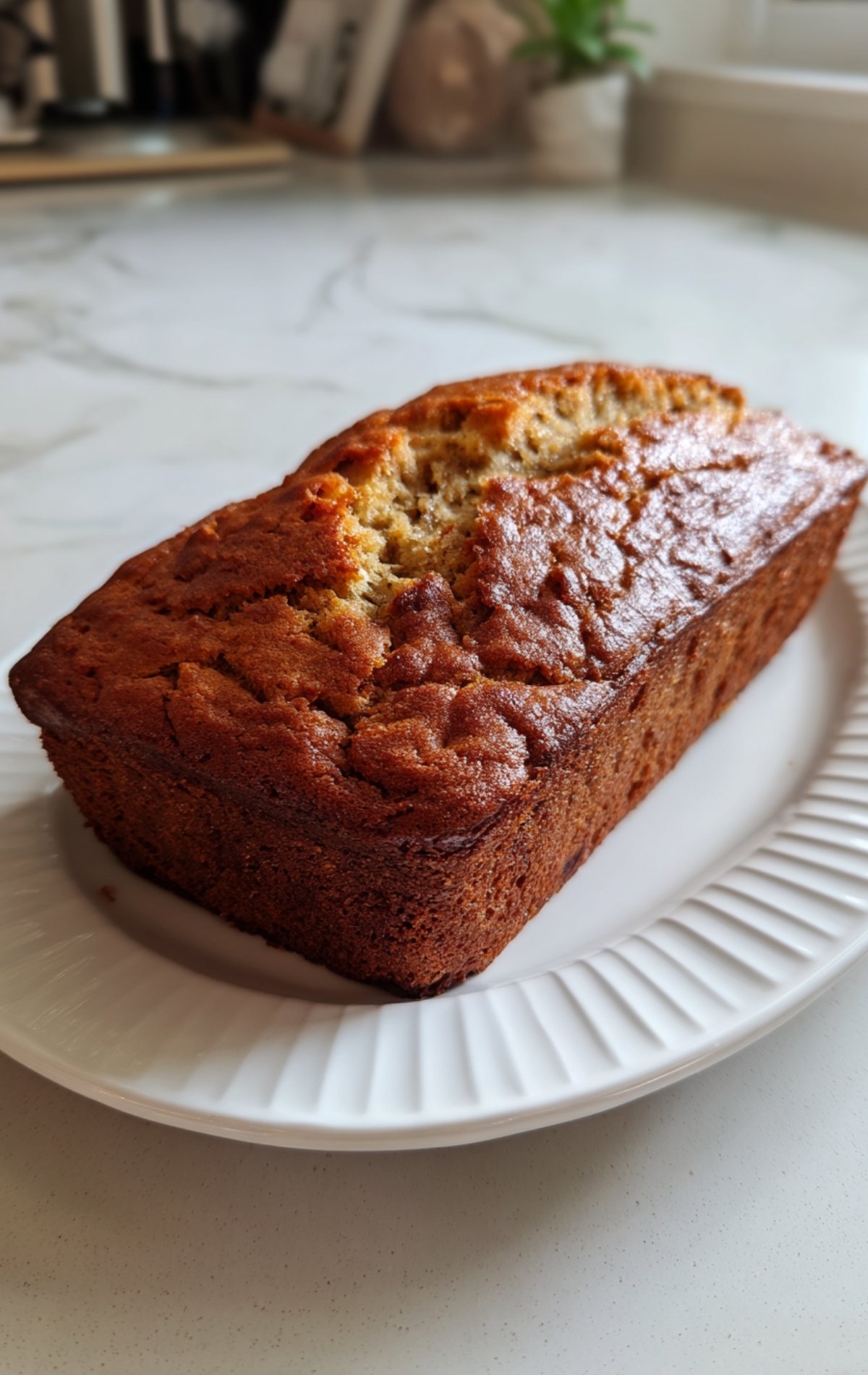 Cake maison moelleux sans sucre, doré et bien levé, sur une assiette en céramique blanche