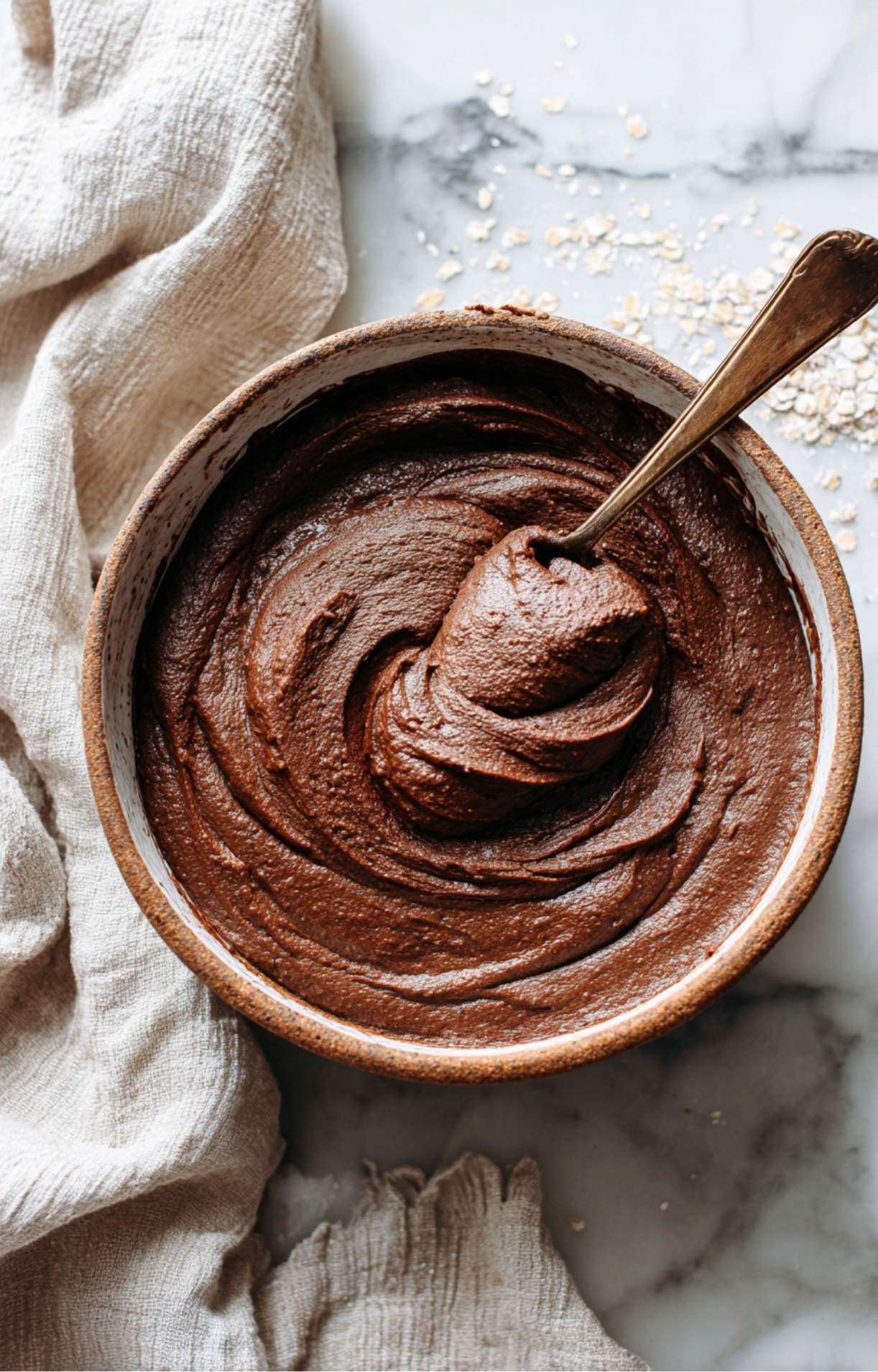 Bol de pâte chocolatée onctueuse en cours de mélange pour un cake protéiné sans sucre, avant l'ajout du chocolat fondu.