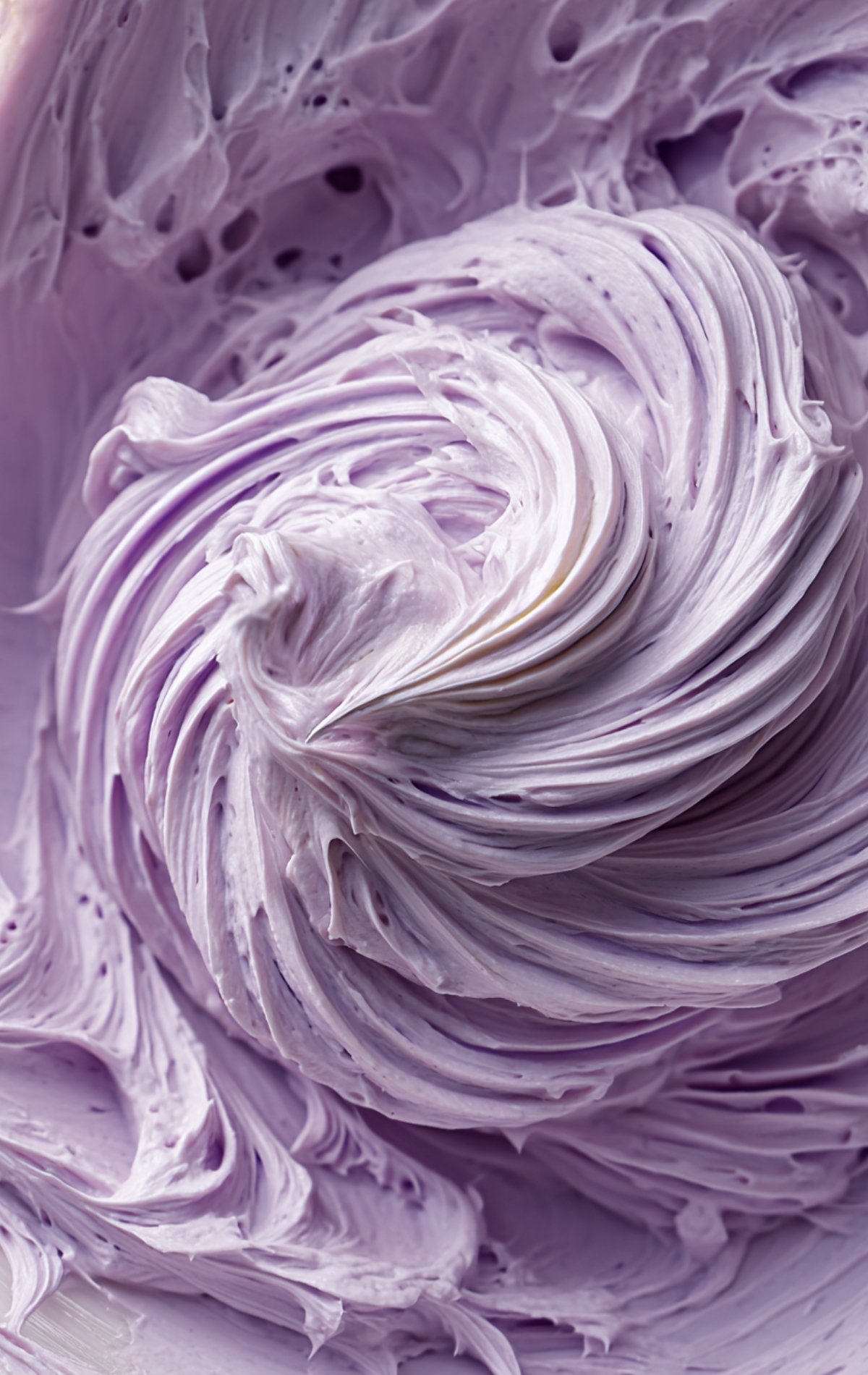 Gros plan sur la crème fouettée violette onctueuse pour le glaçage du bento cake.