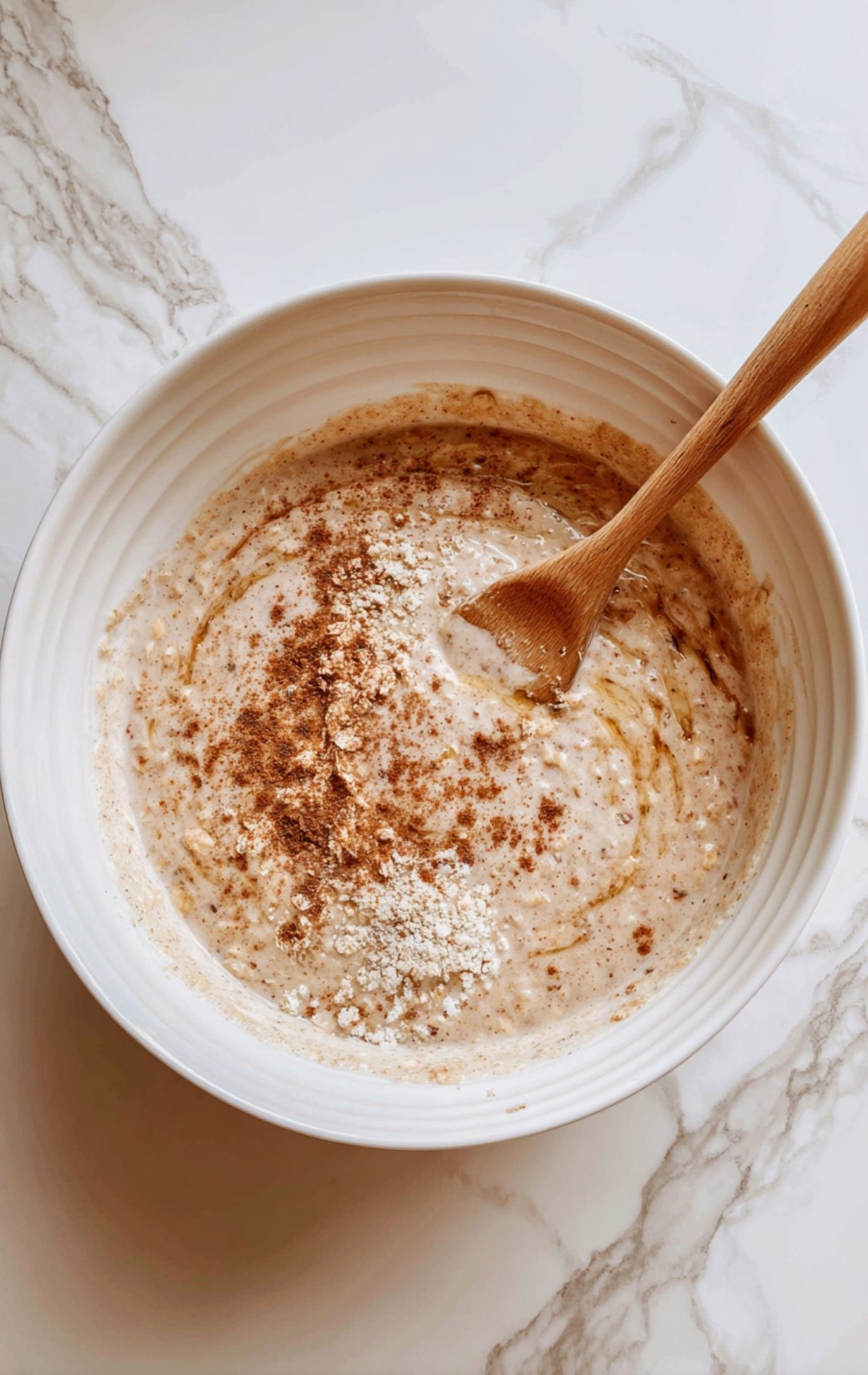 Pâte à cake sans sucre ajoutée dans un moule avec des éclats de cannelle visibles