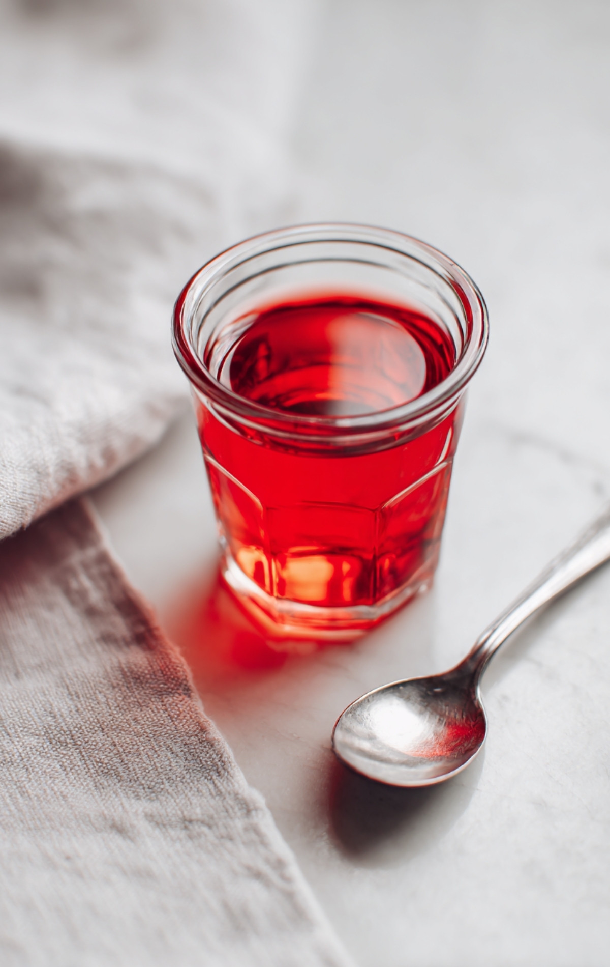 Petit verre de sirop d'imbibage à la confiture, prêt à badigeonner la génoise.