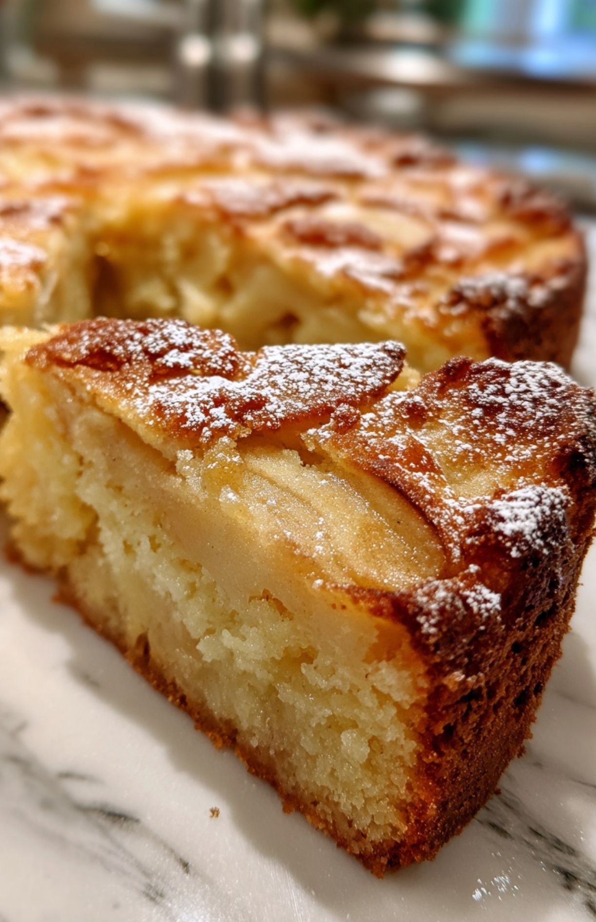 Tranche de gâteau moelleux aux pommes saupoudrée de sucre glace, prête à être servie.