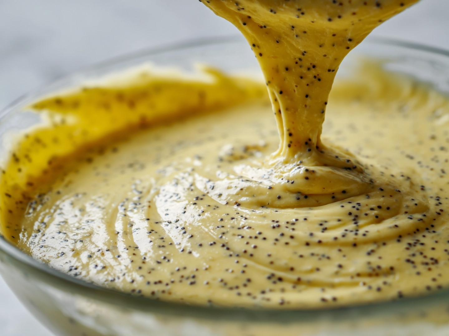 Ajout des graines de pavot dans la pâte à cake citronnée.