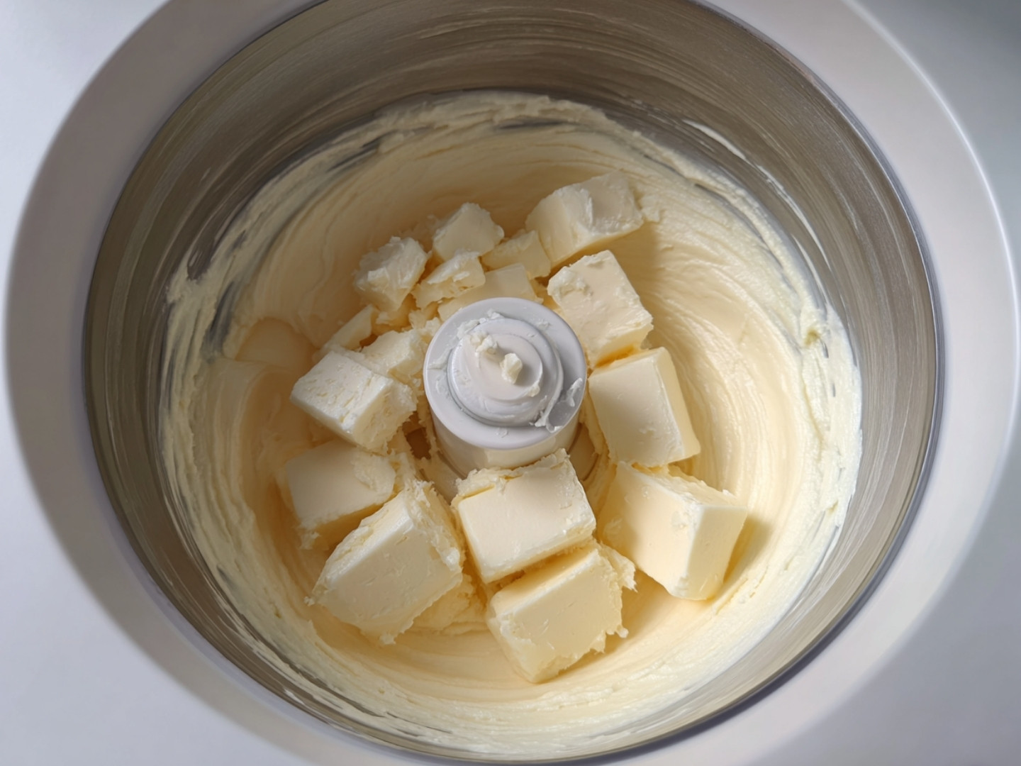 Ingrédients pour la pâte brisée (beurre en cubes) placés dans le bol du Thermomix avant le mixage.