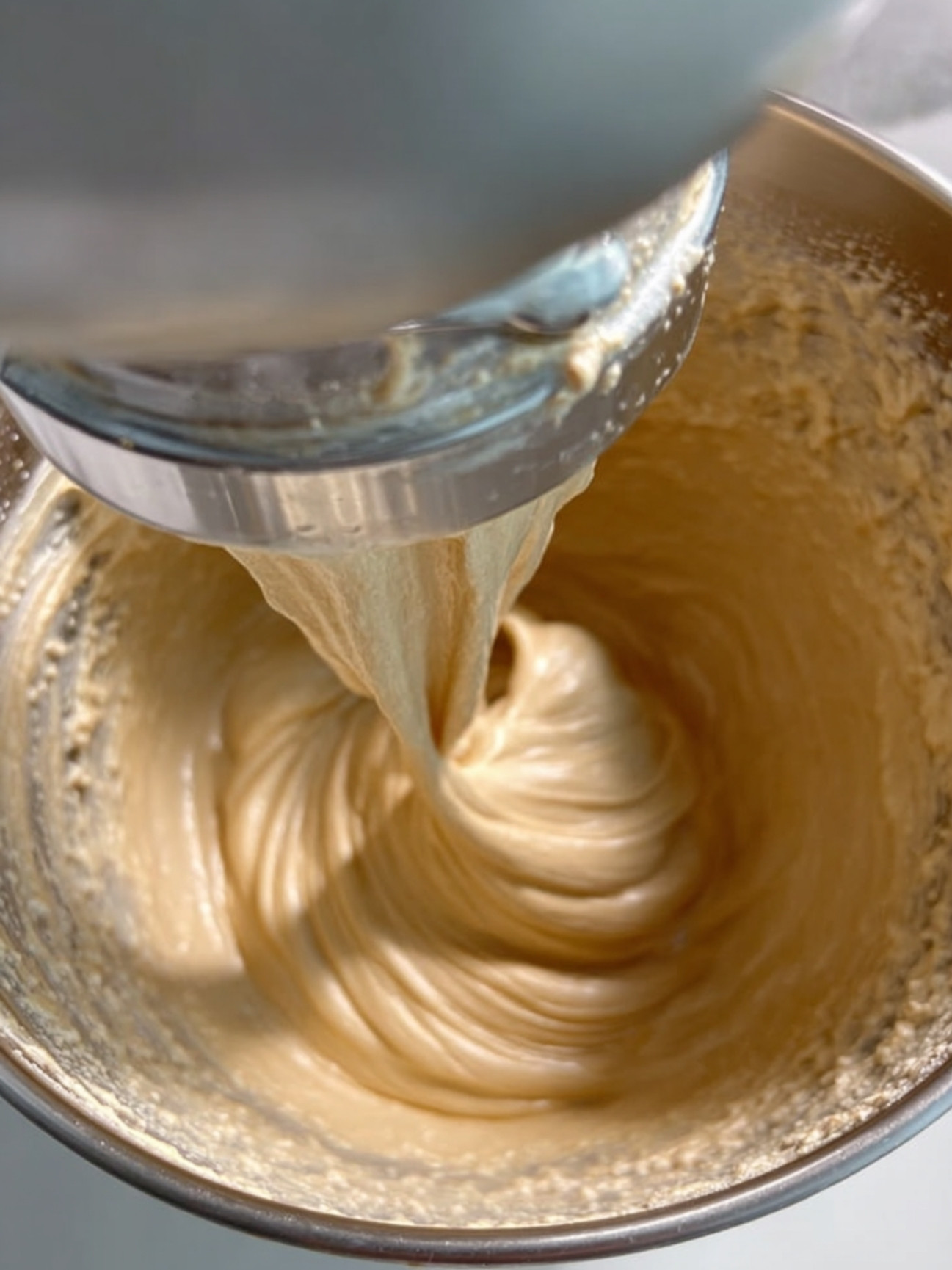 Préparation de la crème pralinée onctueuse au batteur électrique dans un bol inox.