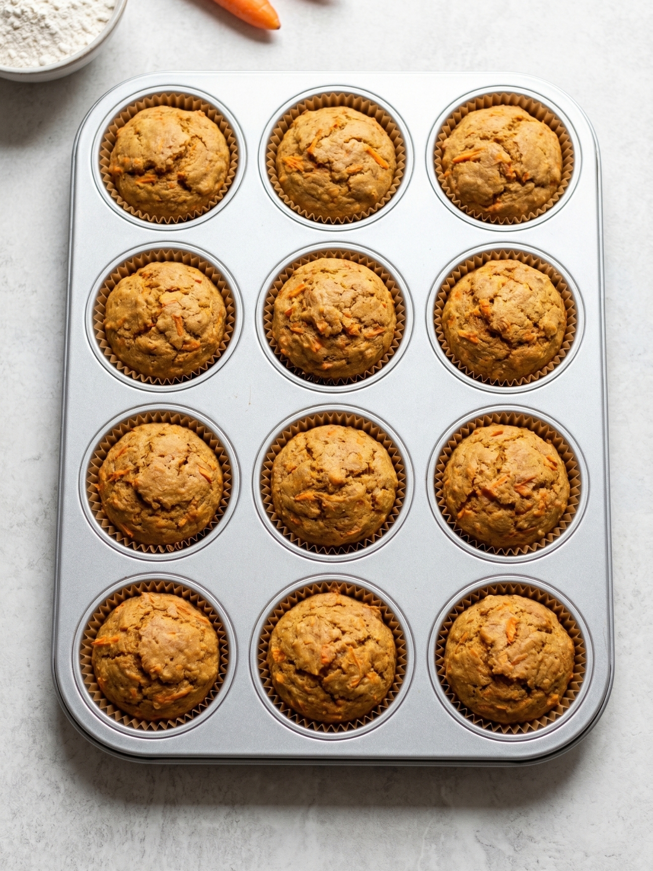 Plusieurs cupcakes type carrot cake canin disposés sur une assiette blanche. Détail du gateau carotte pour chien.