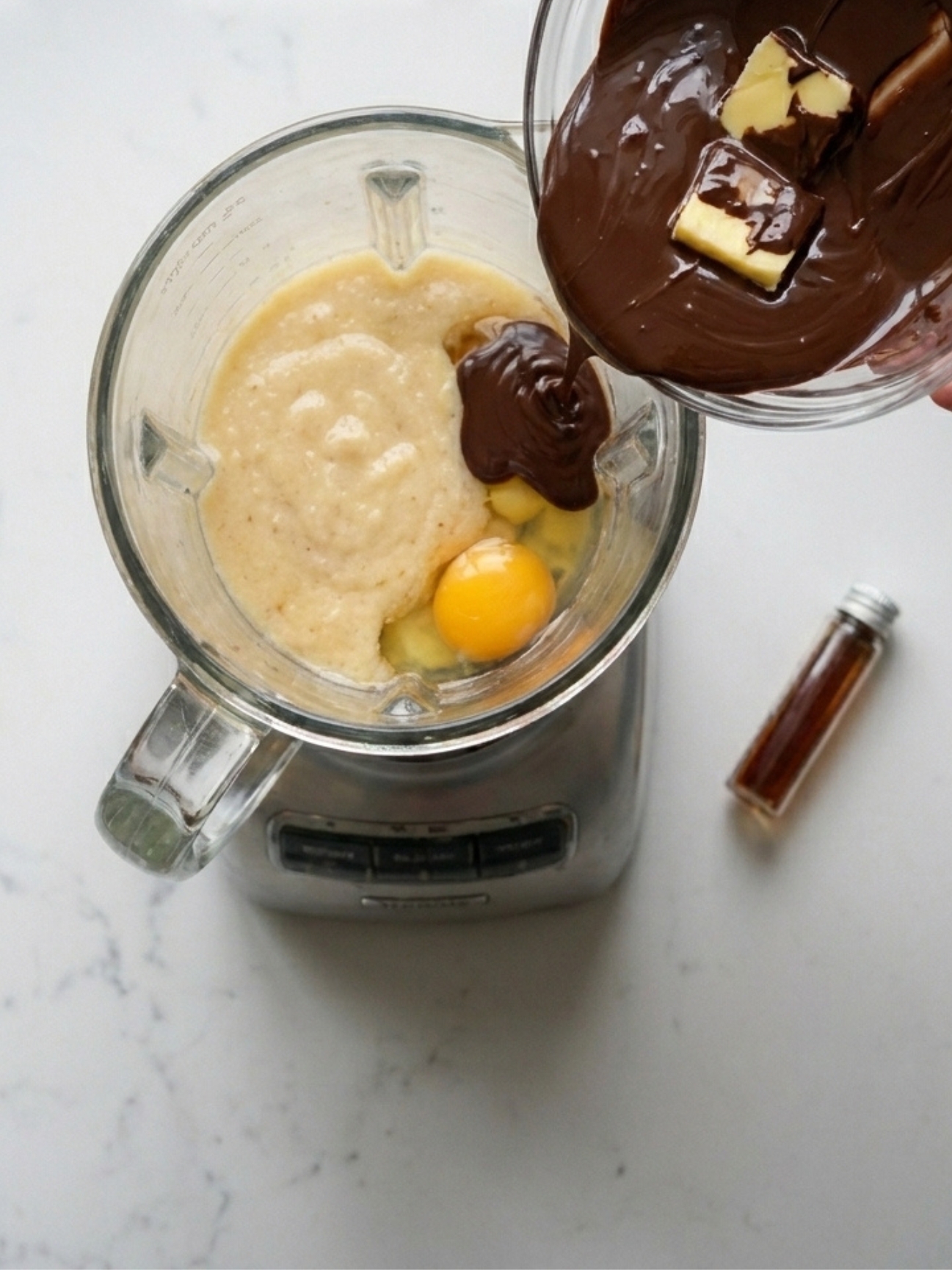 Chocolat fondu versé dans un mixeur pour faire un gâteau banane chocolat.