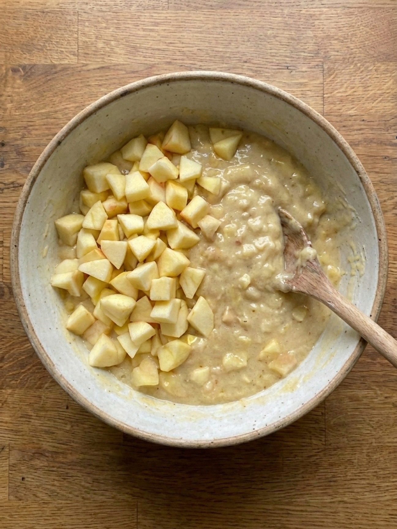 Ajout des morceaux de fruits dans la pâte du gateau banane pomme.