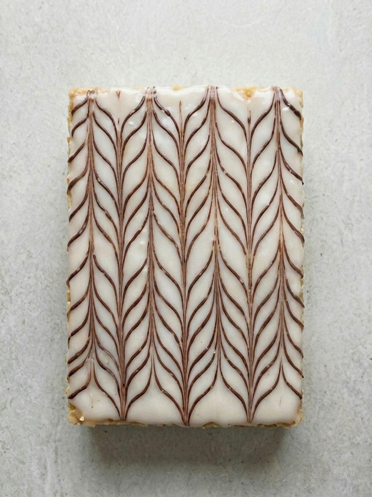 Vue du dessus d un glaçage mille feuille avec son marbrage chocolat géométrique.