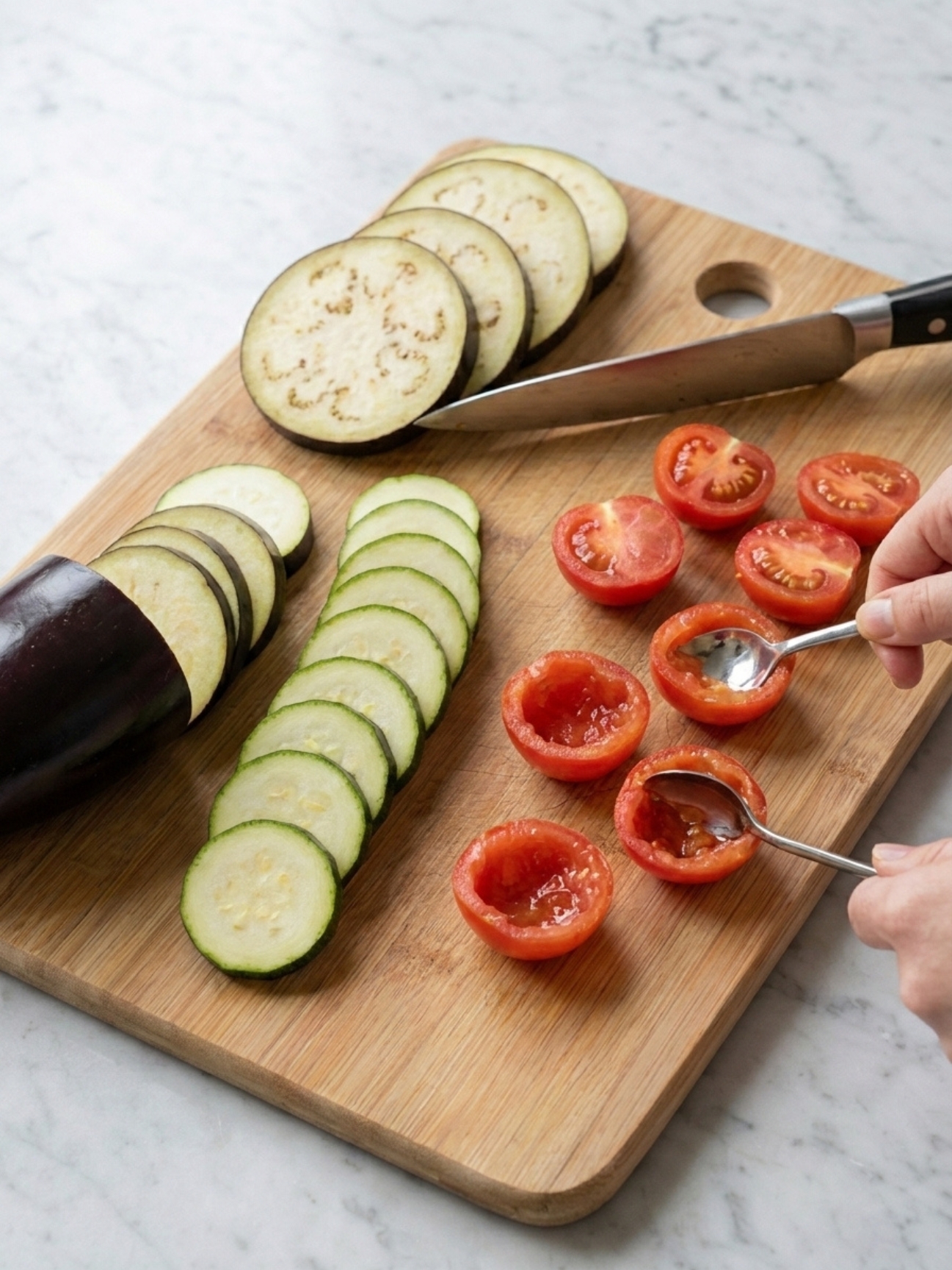 Découpe de courgettes et mille feuille aubergine sur une planche en bois de cuisine.