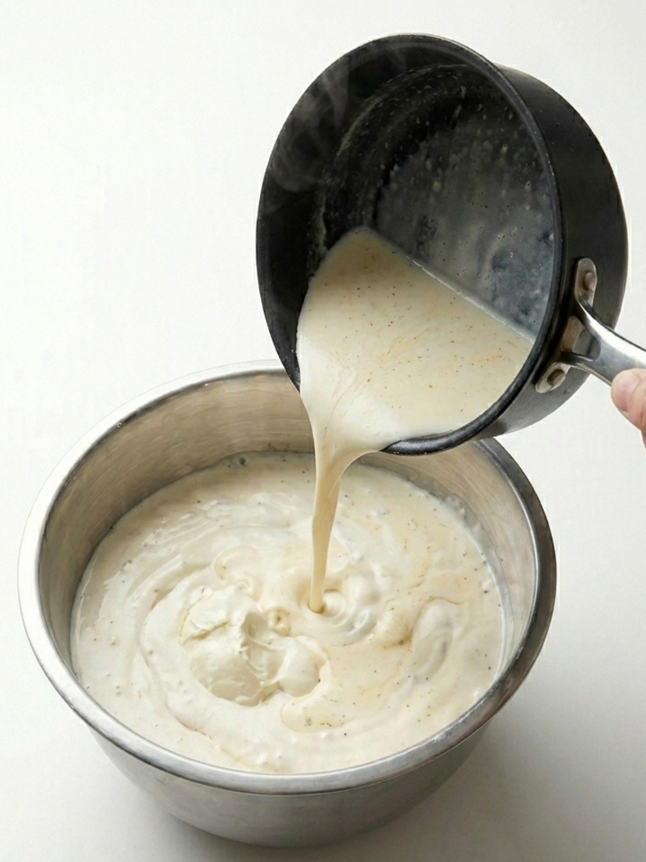 Verser le mélange chaud de crème et gélatine dans un bol en inox contenant de la crème liquide.