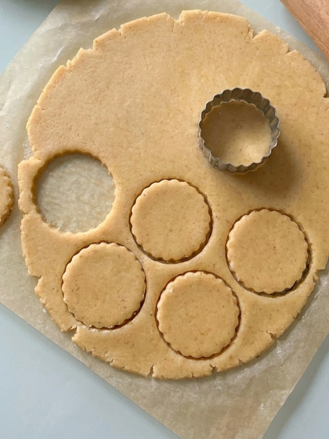 Découpe à l'emporte-pièce de la pâte pour la recette de galette bretonne biscuit sur table.