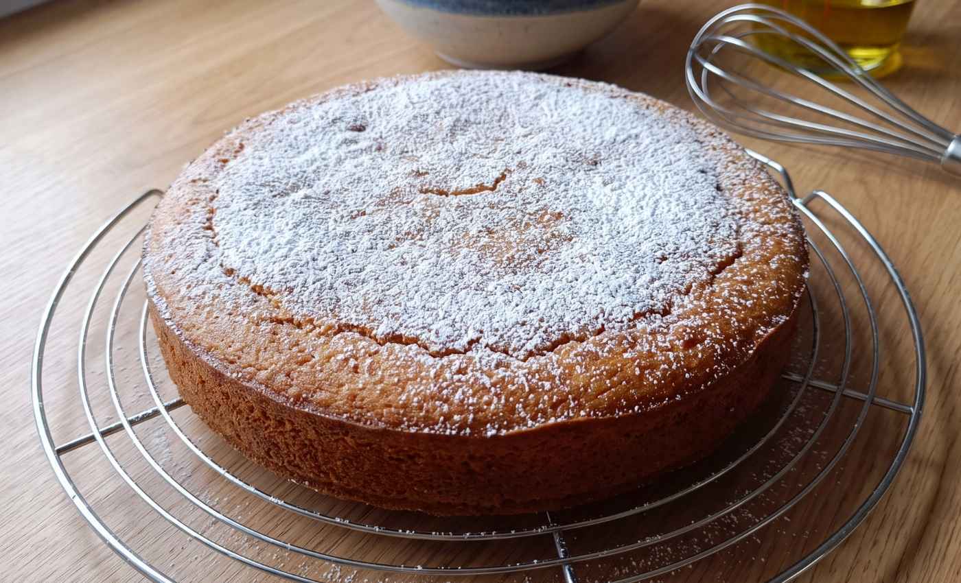 Gâteau simple et moelleux fait maison, doré et saupoudré de sucre glace après cuisson.